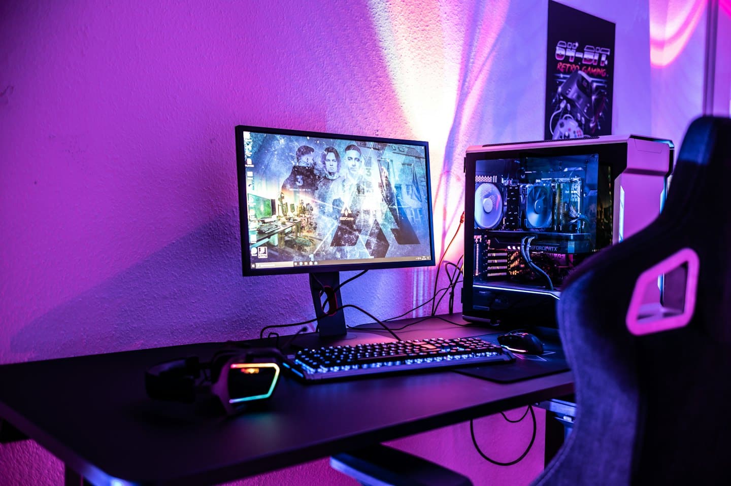 Scrivania da gamer con PC, monitor, tastiera e cuffie luminosi.
