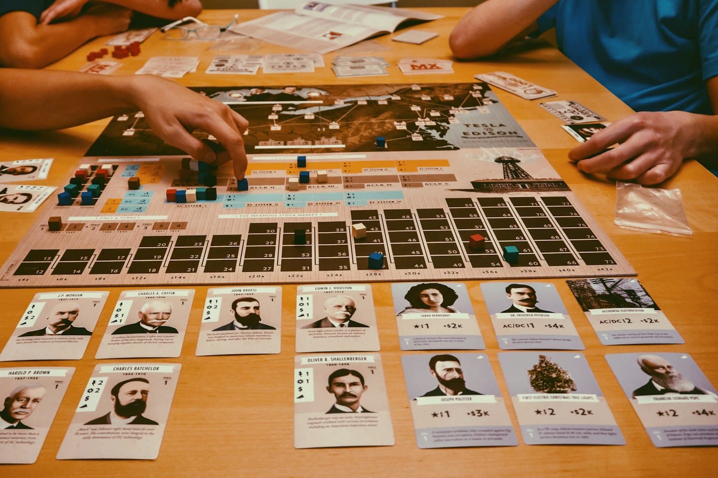 Mani di persone che muovono pezzi su un dettagliato gioco da tavolo.